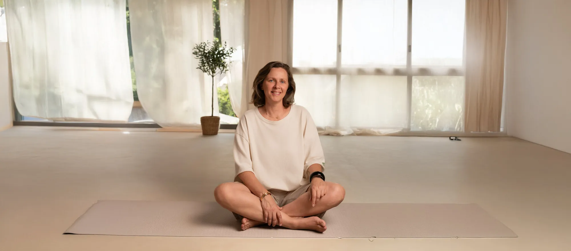 Lise Dehaye assise en tailleur dans une salle lumineuse