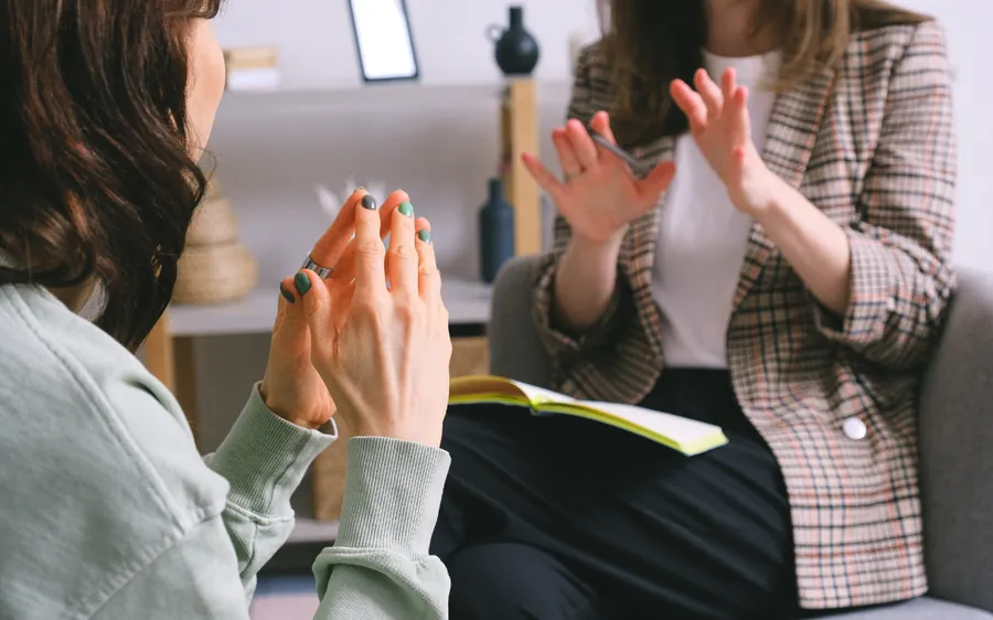 Deux femmes échangent autour d’une table pendant un rendez-vous